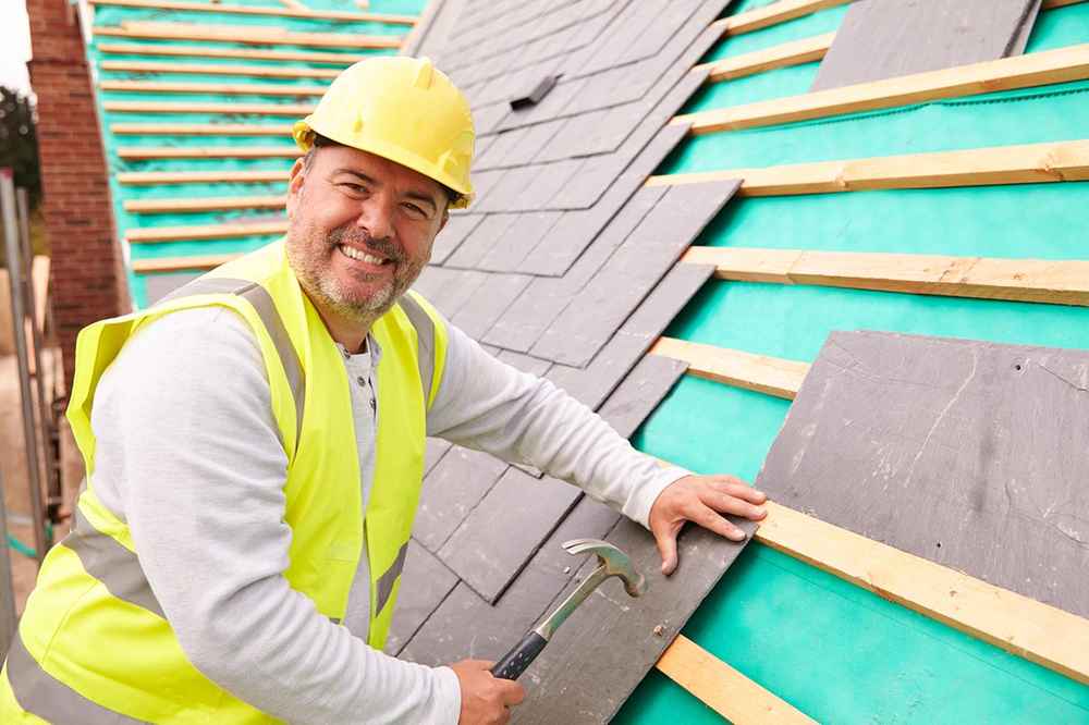 Roofer installing an asphalt roofing shingle